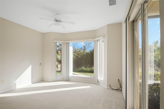 spare room featuring light carpet and ceiling fan