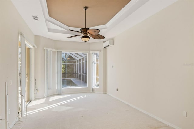 empty room featuring a wall mounted AC, light colored carpet, ceiling fan, a raised ceiling, and crown molding