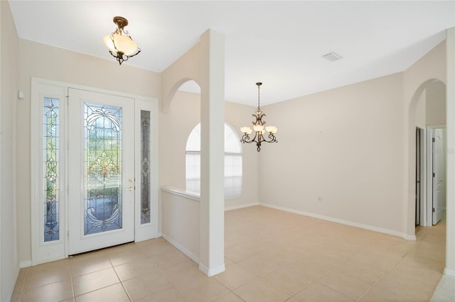 foyer with light tile patterned floors and a notable chandelier