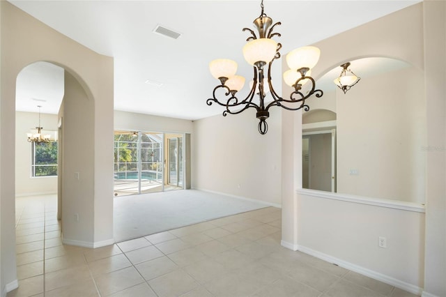 unfurnished room featuring light colored carpet and a notable chandelier