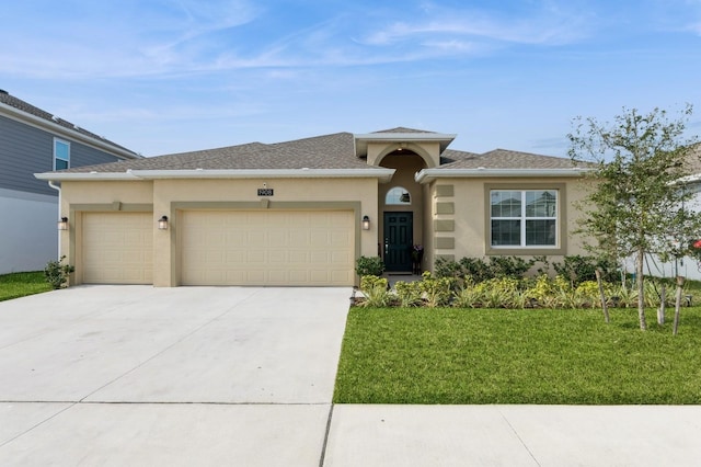 prairie-style house featuring a garage, driveway, a front lawn, and stucco siding