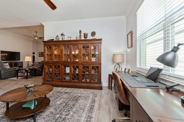 home office featuring a ceiling fan, wood tiled floor, crown molding, and baseboards