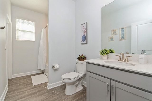 full bath with baseboards, toilet, shower / tub combo with curtain, vanity, and wood finish floors