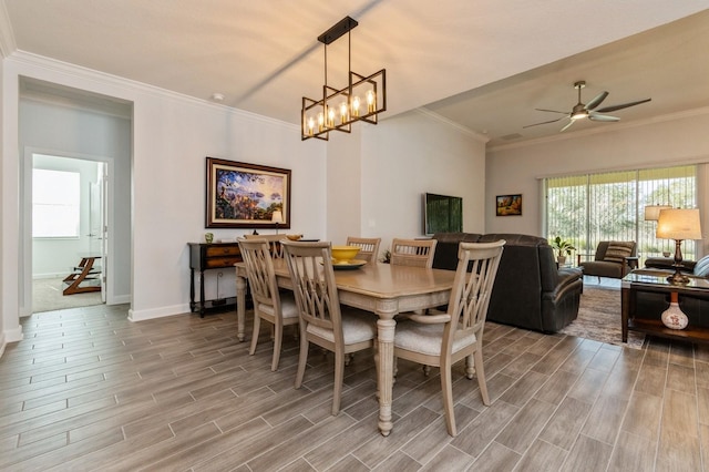 dining space featuring baseboards, ceiling fan with notable chandelier, ornamental molding, and wood finish floors