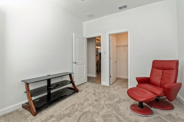 living area featuring carpet, visible vents, and baseboards