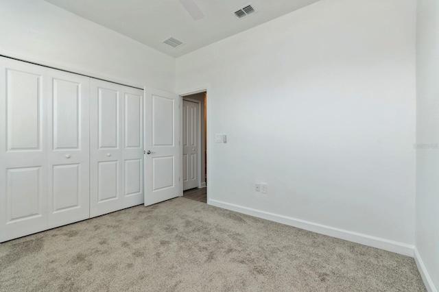 unfurnished bedroom featuring carpet floors, a closet, visible vents, and baseboards