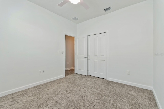 unfurnished bedroom with carpet floors, a closet, visible vents, and baseboards