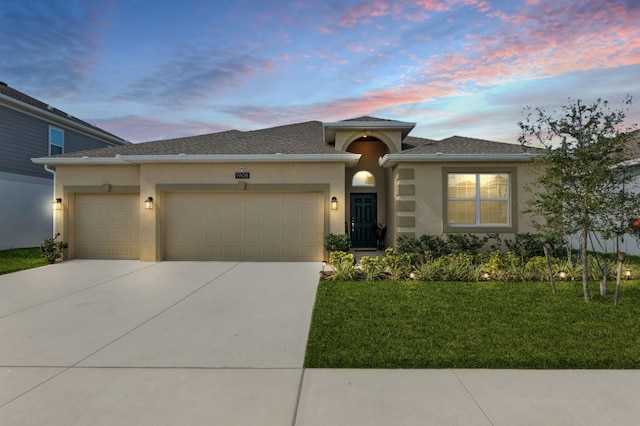 view of front of house featuring driveway, an attached garage, and stucco siding