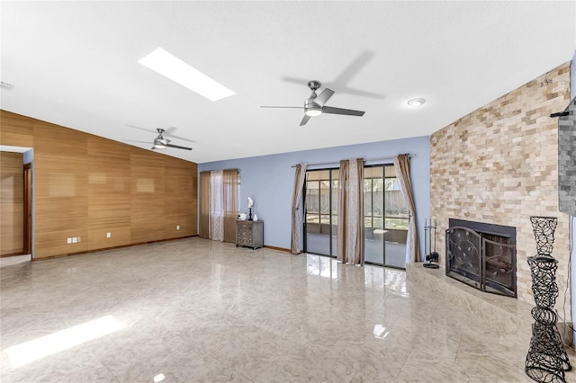3547 Medford Rd, Casselberry, FL 32707 - unfurnished living room featuring a ceiling fan, lofted ceiling, a large fireplace, a skylight, and wood walls