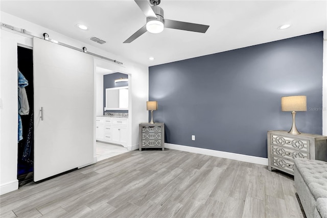 3547 Medford Rd, Casselberry, FL 32707 - unfurnished bedroom with a barn door, light wood-style flooring, recessed lighting, ensuite bathroom, and a ceiling fan