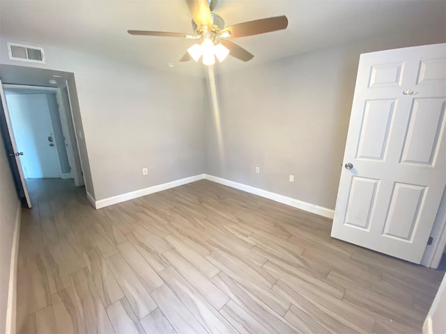 empty room with light hardwood / wood-style flooring and ceiling fan