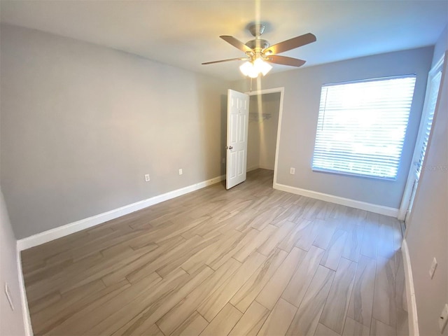 unfurnished bedroom with light hardwood / wood-style flooring, a closet, and ceiling fan