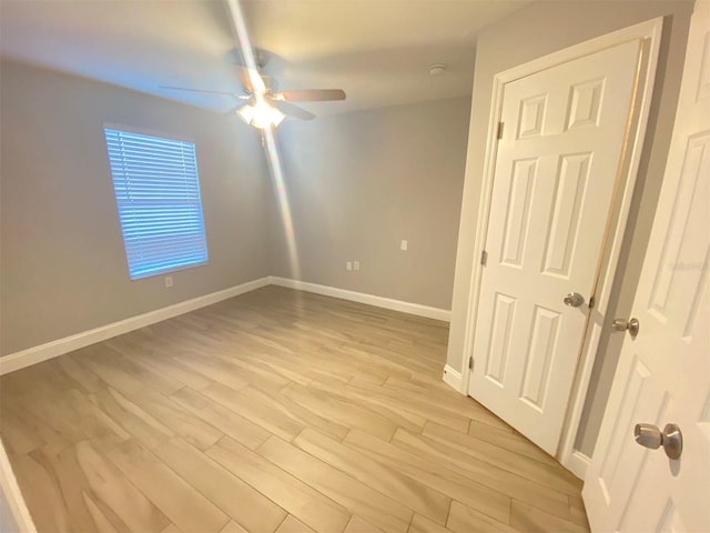 empty room with ceiling fan and light hardwood / wood-style floors