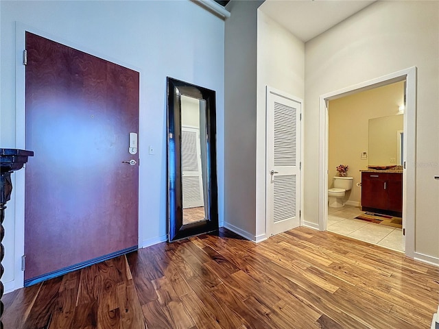 foyer featuring a towering ceiling and light wood-type flooring