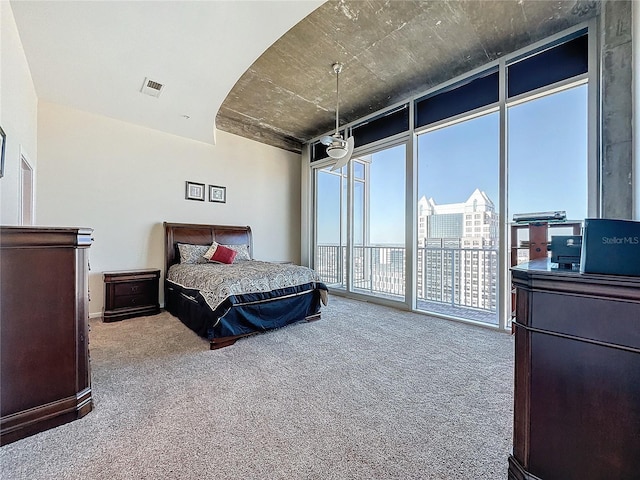 bedroom featuring carpet floors, a wall of windows, and access to outside