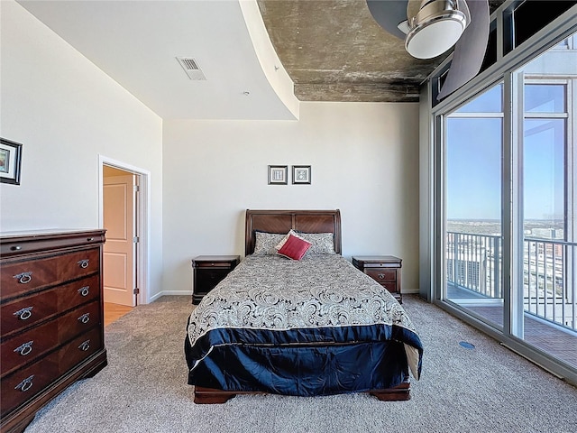 bedroom with a water view, light carpet, and access to exterior