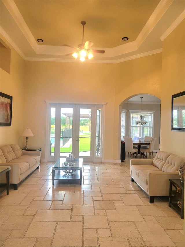 living room with a raised ceiling, a healthy amount of sunlight, and french doors