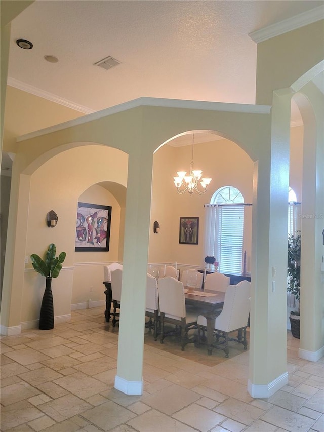 dining area with crown molding and a chandelier