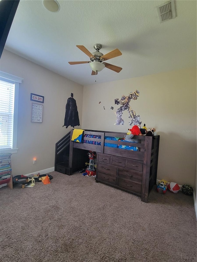 rec room with a textured ceiling, ceiling fan, and carpet flooring