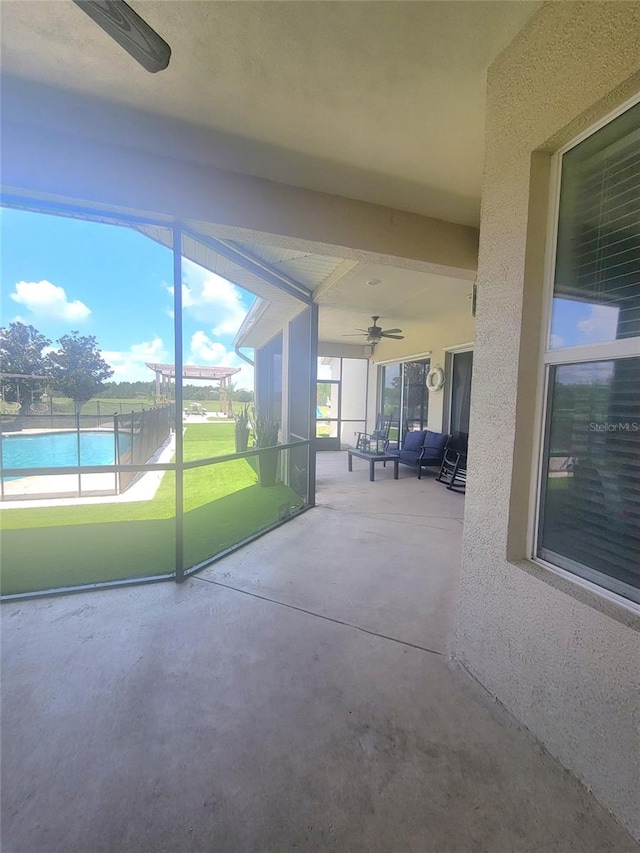 unfurnished sunroom featuring ceiling fan