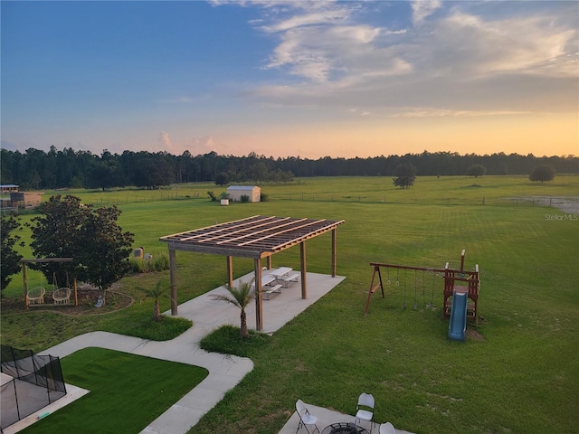 view of property's community with a patio, a yard, and a rural view