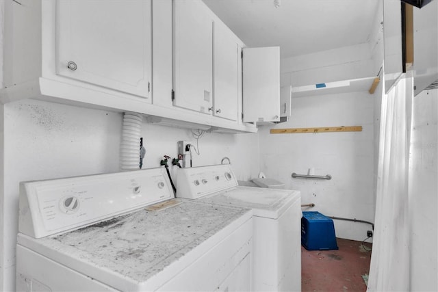 washroom featuring cabinets and washer and clothes dryer