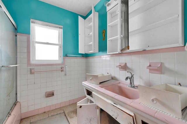 bathroom featuring shower / bath combination with glass door and tile walls