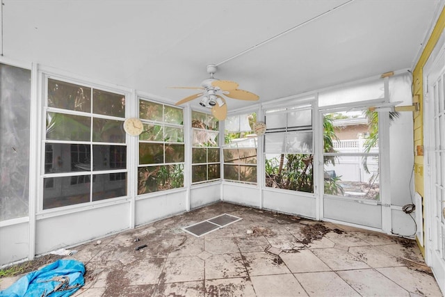 unfurnished sunroom featuring ceiling fan