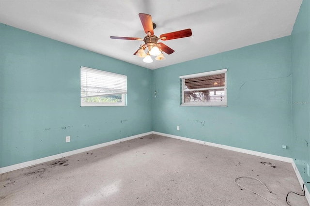 unfurnished room featuring ceiling fan and plenty of natural light