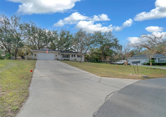 single story home featuring a garage, concrete driveway, and a front yard