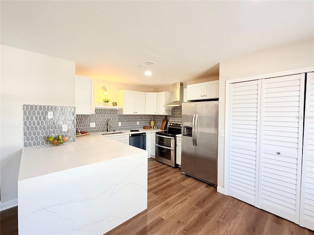 kitchen with sink, white cabinetry, stainless steel appliances, tasteful backsplash, and wall chimney exhaust hood