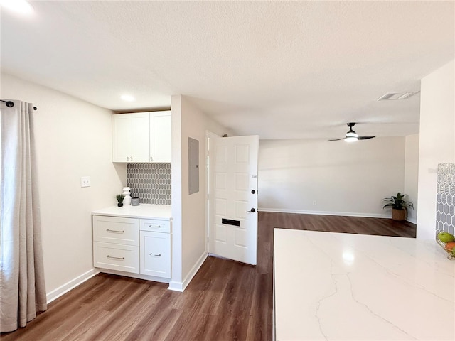 kitchen with ceiling fan, dark wood-type flooring, electric panel, and white cabinets