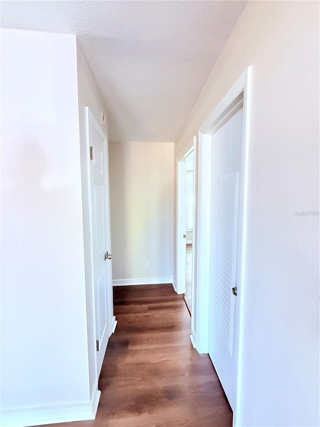 hall featuring dark hardwood / wood-style flooring and a textured ceiling