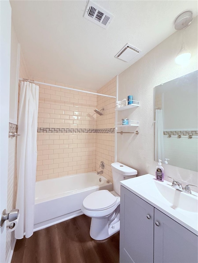 bathroom featuring wood-type flooring, toilet, vanity, and a textured ceiling