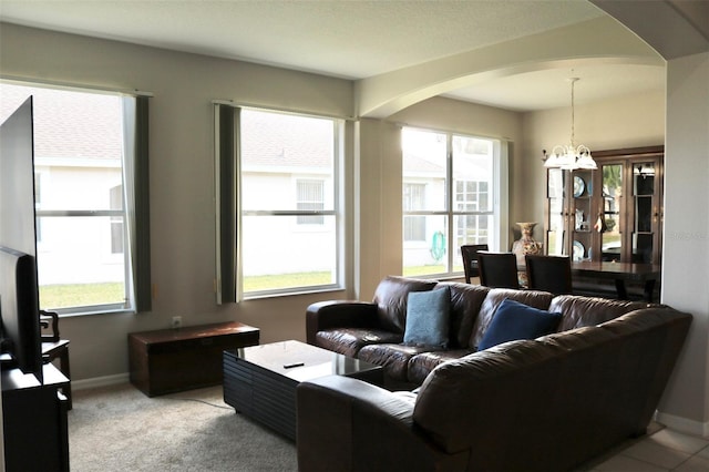 living room with light carpet and a notable chandelier