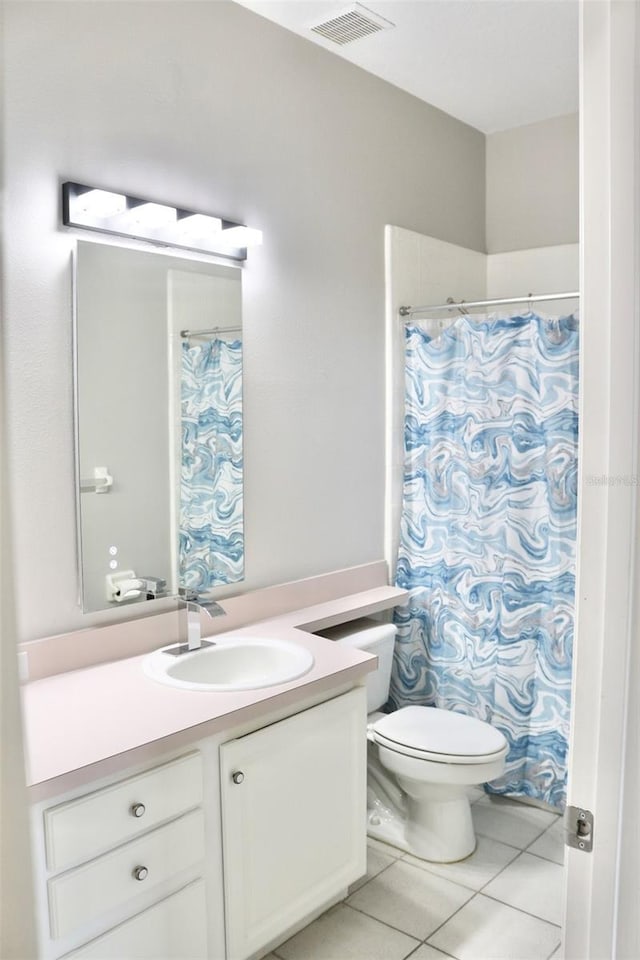 bathroom featuring vanity, walk in shower, tile patterned floors, and toilet