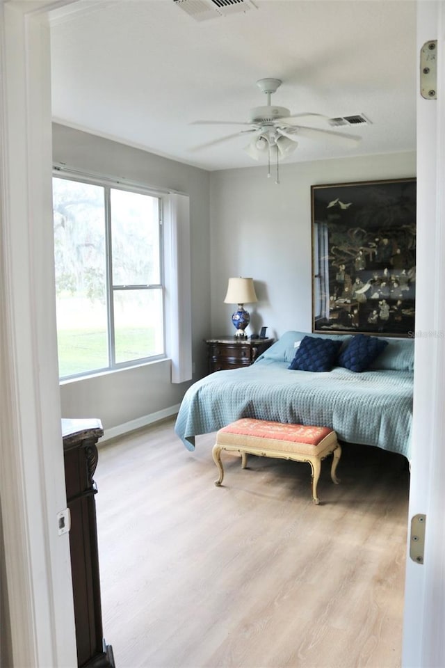 bedroom with light hardwood / wood-style floors and ceiling fan