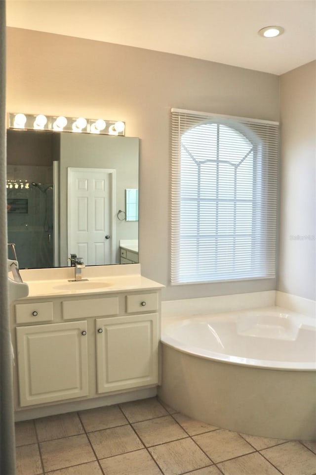 bathroom featuring independent shower and bath, vanity, and tile patterned floors