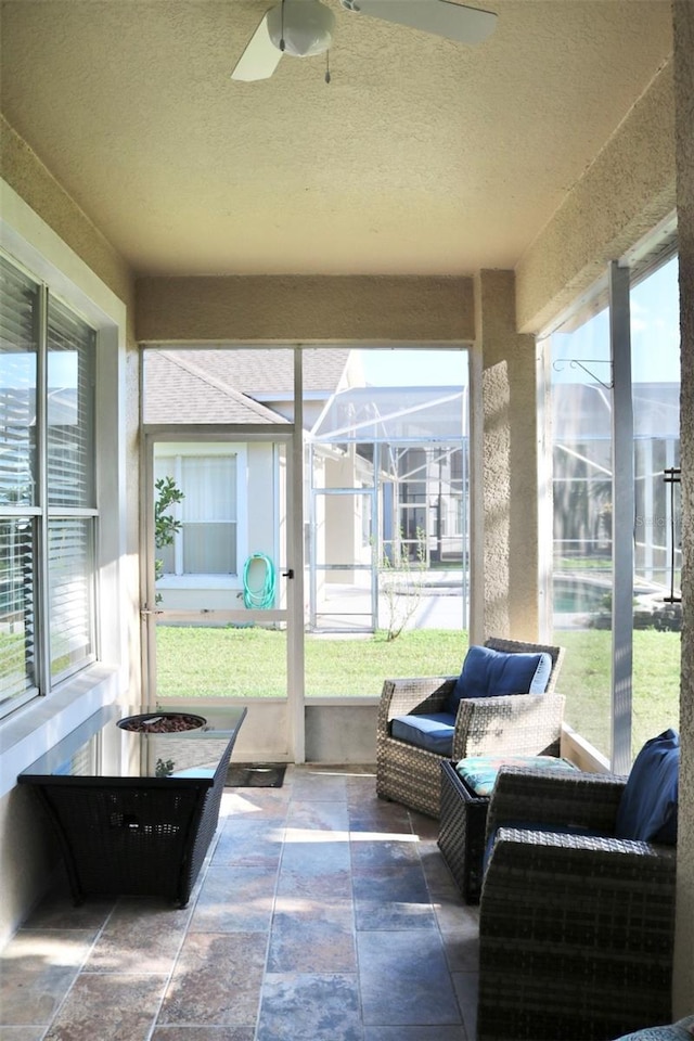 sunroom / solarium featuring a ceiling fan and plenty of natural light