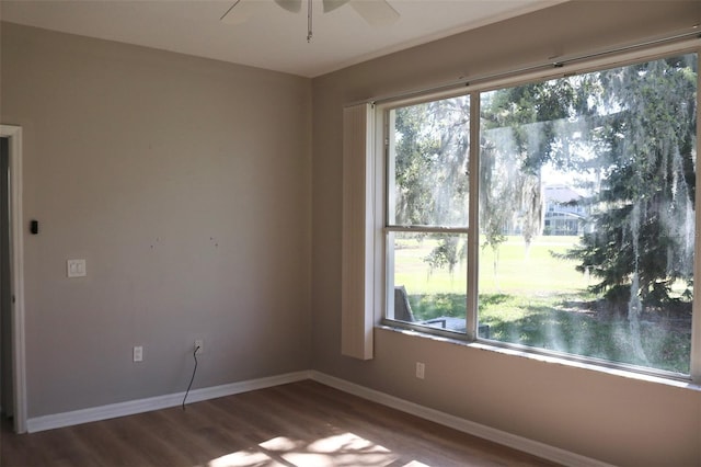 empty room featuring a ceiling fan, baseboards, and wood finished floors