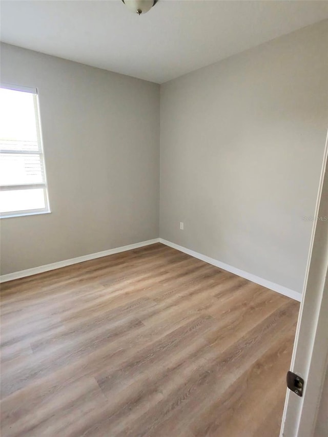 unfurnished room featuring baseboards and wood finished floors