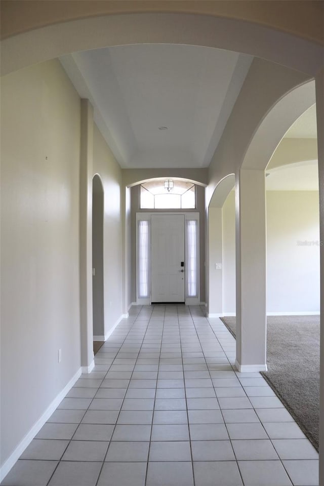 entryway featuring light carpet, baseboards, and light tile patterned flooring