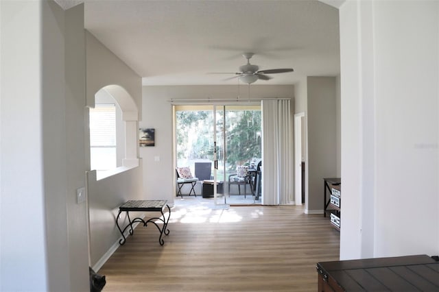 interior space featuring baseboards, a ceiling fan, and wood finished floors