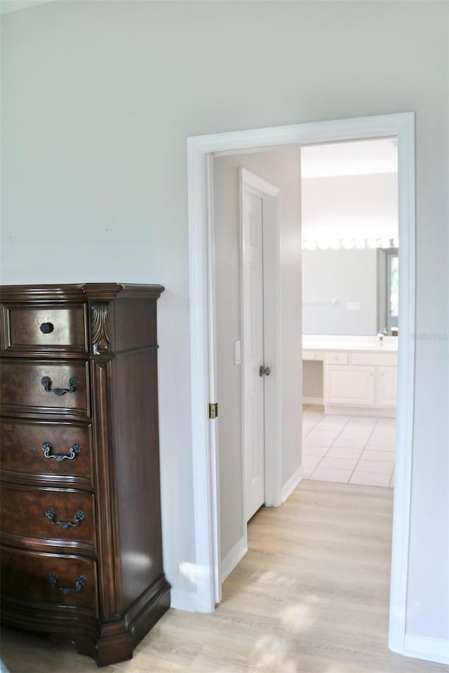 hallway with light wood-style flooring and baseboards