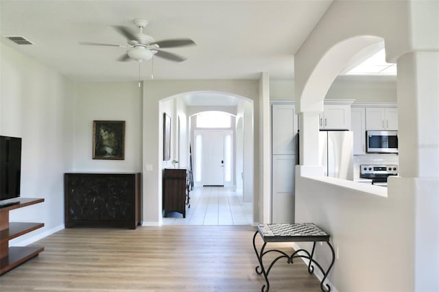 interior space featuring light wood-type flooring, visible vents, and baseboards