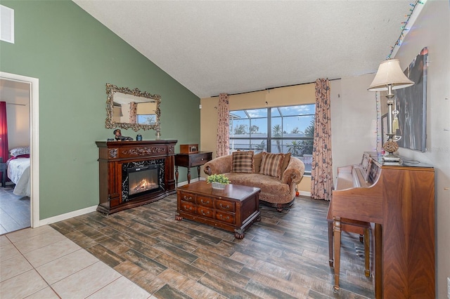 living room featuring lofted ceiling, hardwood / wood-style flooring, and a textured ceiling