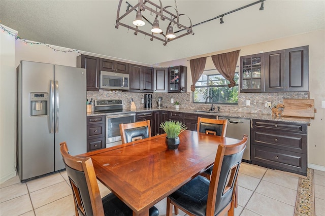 dining room with sink, light tile patterned floors, and a chandelier