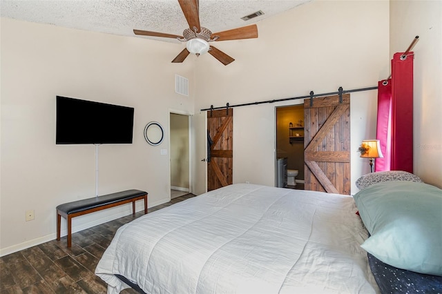 bedroom featuring dark hardwood / wood-style floors, a barn door, high vaulted ceiling, and a textured ceiling