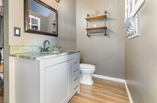 bathroom featuring vanity, wood-type flooring, and toilet