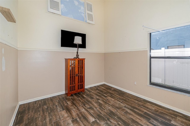 empty room with dark hardwood / wood-style flooring